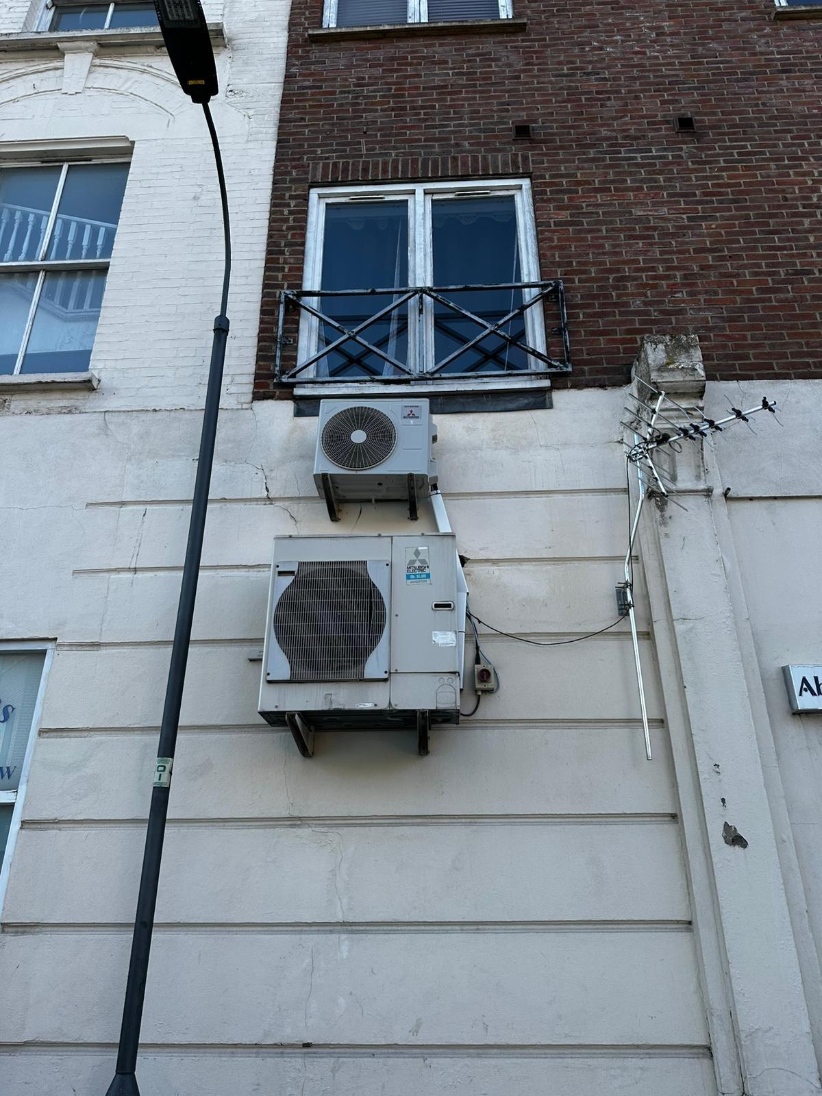 Commercial AC outdoor units wall-mounted on building facade