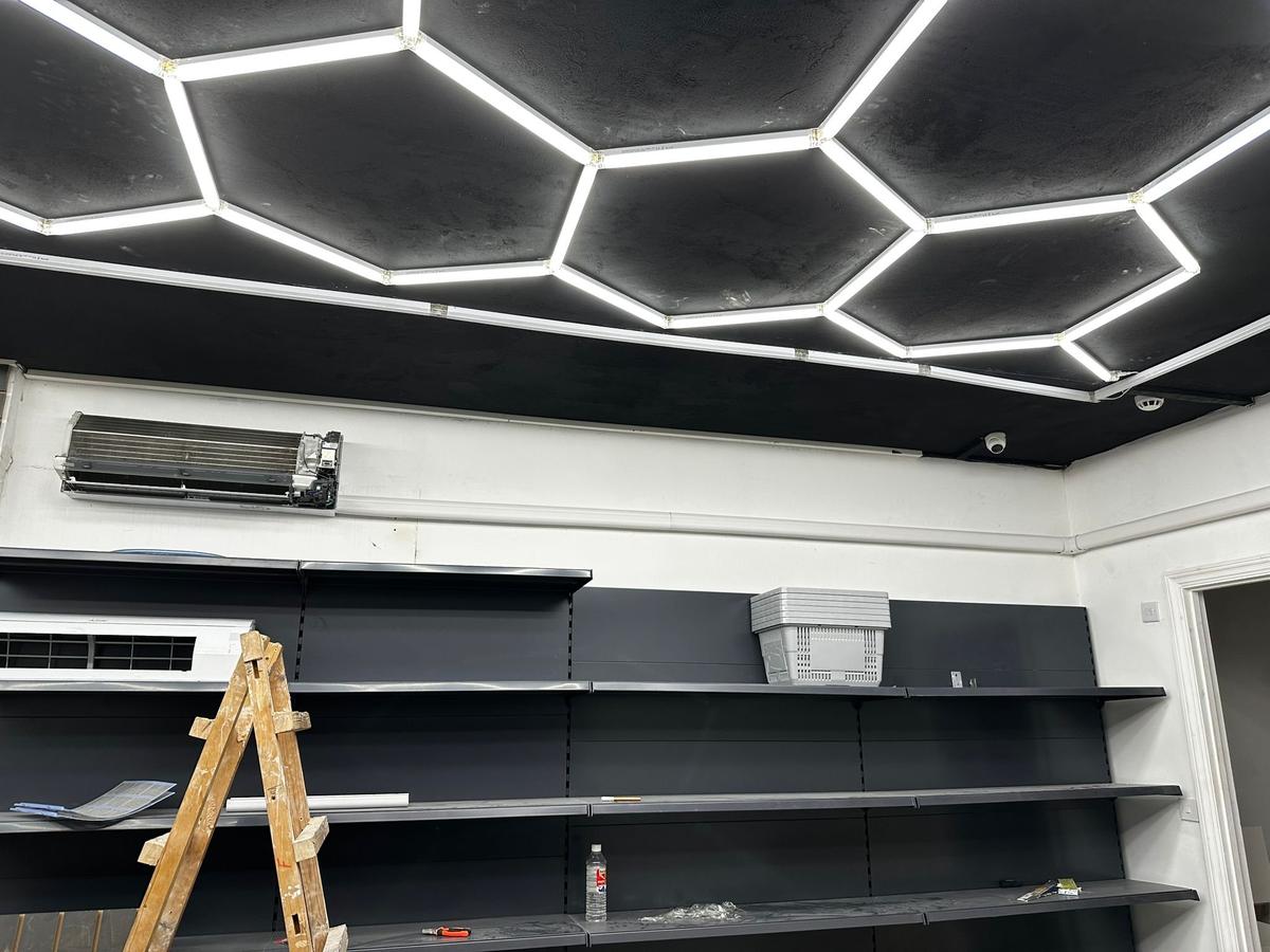 Commercial retail fit-out with ceiling-mounted evaporator and hexagonal LED lighting